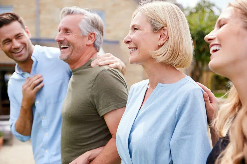 family with senior parents and adult offspring walking and talking in garden together